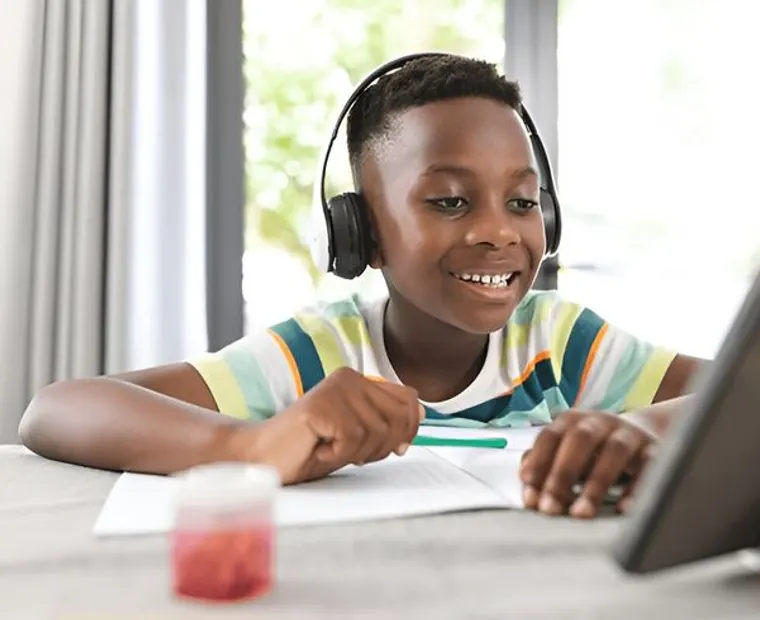 A school-age learner working through a lesson with an online tutor